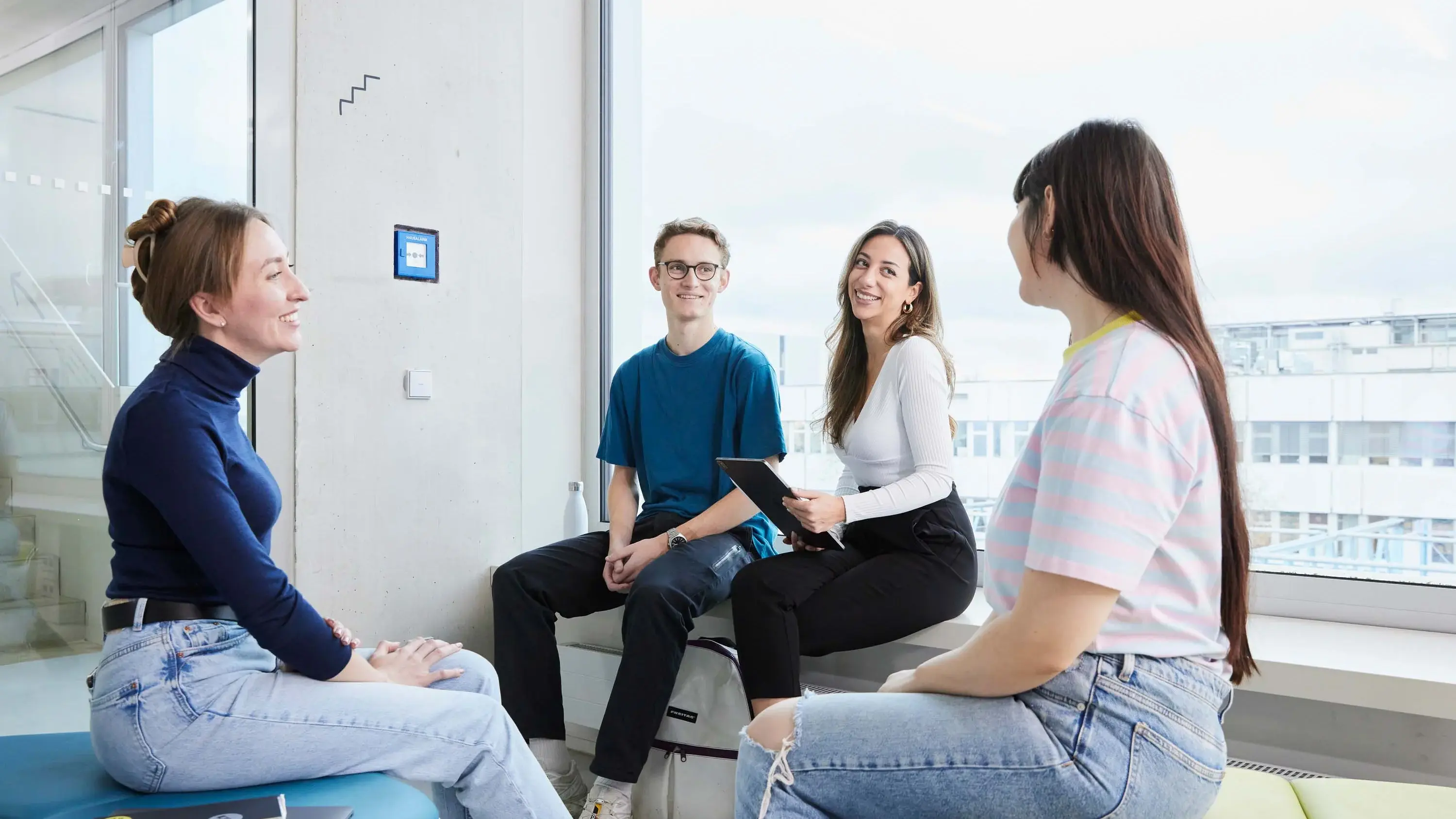 Studierende besprechen sich in einer kleinen Gruppe.