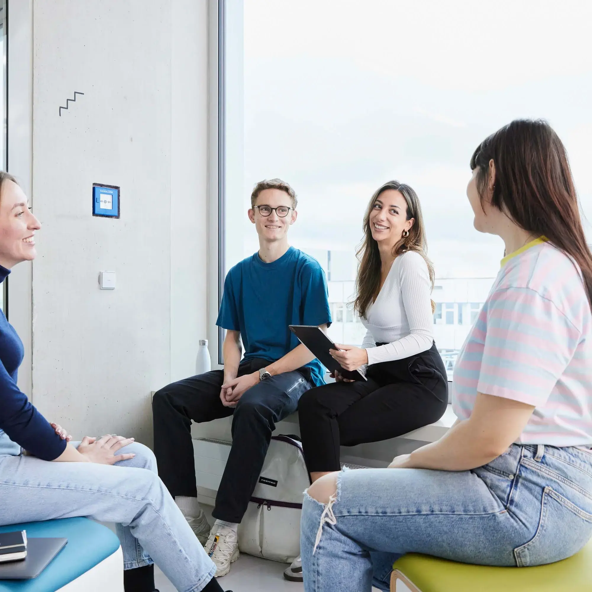 Studierende besprechen sich in einer kleinen Gruppe.