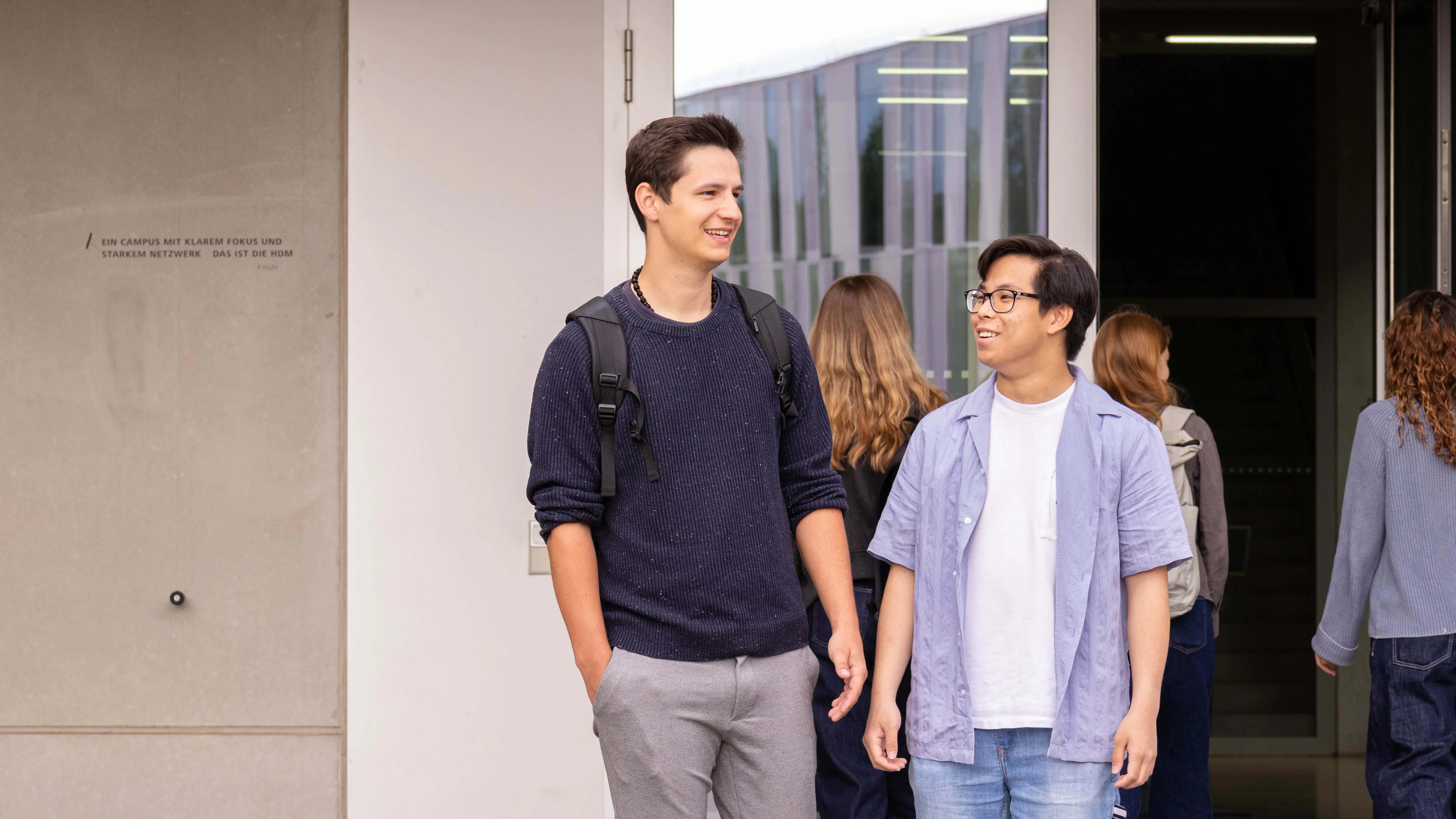 Zwei Studenten verlassen den sogenannten Würfel, ein Nebengebäude der Hochschule der Medien.